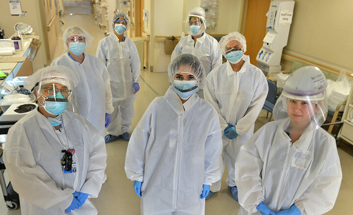 Group of doctors in full Covid-19 protection suits and masks