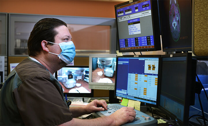 Doctor reviewing results on computer wearing mask