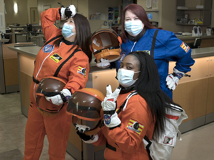 Nurses dressed in astronaut suits wearing masks for ICOUGH