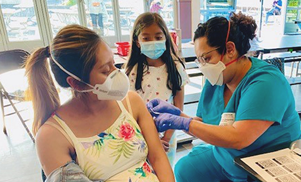 Nurse giving woman patient Covid vaccination